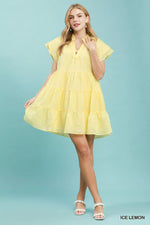 Woman wearing a yellow dress against a light blue background