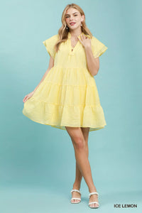 Woman wearing a yellow dress against a light blue background
