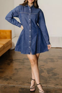 Woman wearing a blue denim dress in an indoor setting