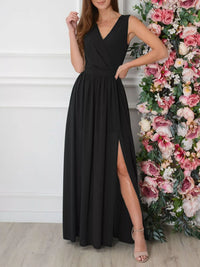 Woman wearing a black dress with a slit, standing next to a floral arrangement.
