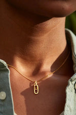 Gold necklace with a pendant worn by a person