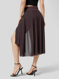 Brown skirt with a high slit worn by a model on a gray background