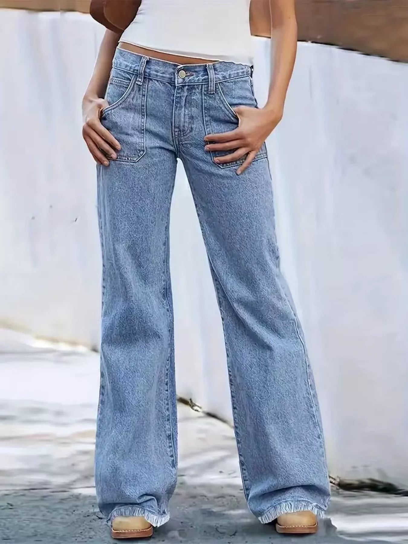 Person wearing light blue wide-leg jeans against a neutral background