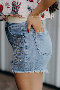Close-up of a person wearing a denim skirt with decorative stitching.