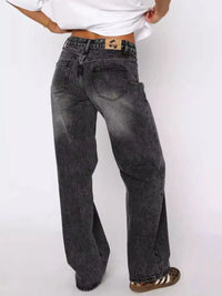 Person wearing black acid-wash jeans on a white background