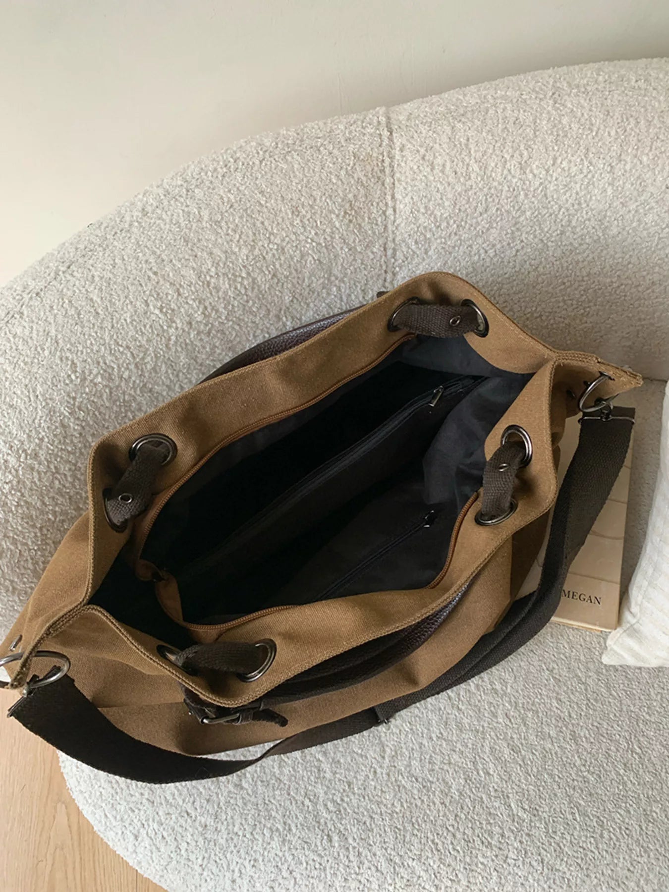 Brown leather bag with black interior on a textured surface