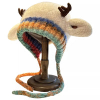 Colorful animal-themed hat with striped pattern on a stand against a white background