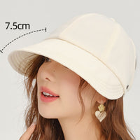 Beige sun hat with a measurement label on a plain background
