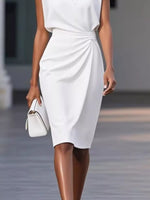 Woman wearing a white dress holding a matching handbag on a blurred background