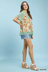 Woman wearing a floral blouse and denim shorts on a light blue background