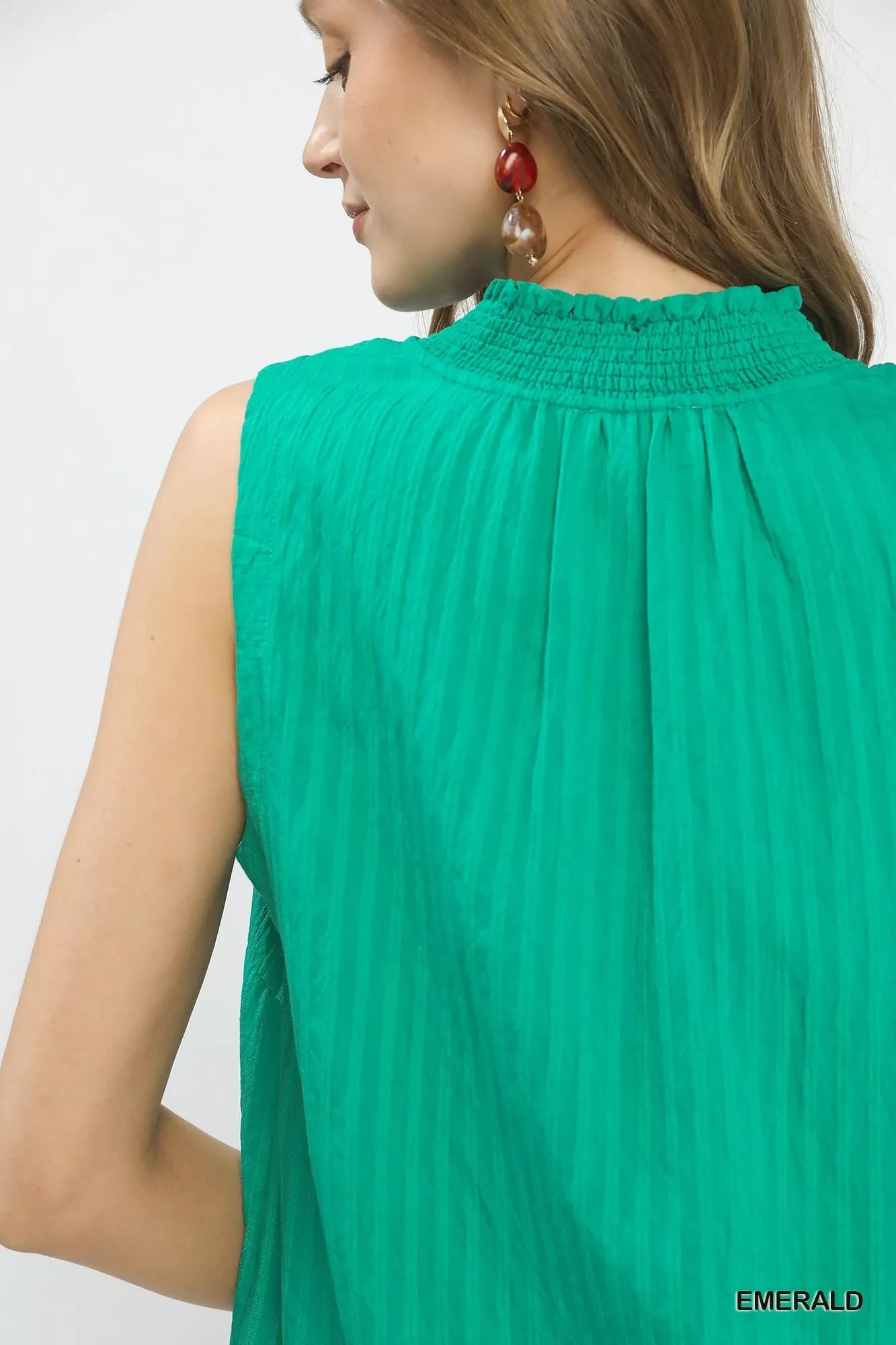 Green sleeveless top worn by a model on a white background