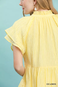 Yellow pleated dress with ruffled sleeves on a light blue background