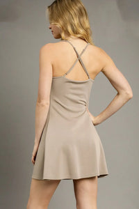 Woman wearing a beige dress against a gray background