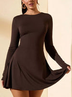 Woman wearing a brown long-sleeve dress against a beige background