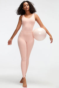 Woman wearing a pink bodysuit holding a balloon against a white background