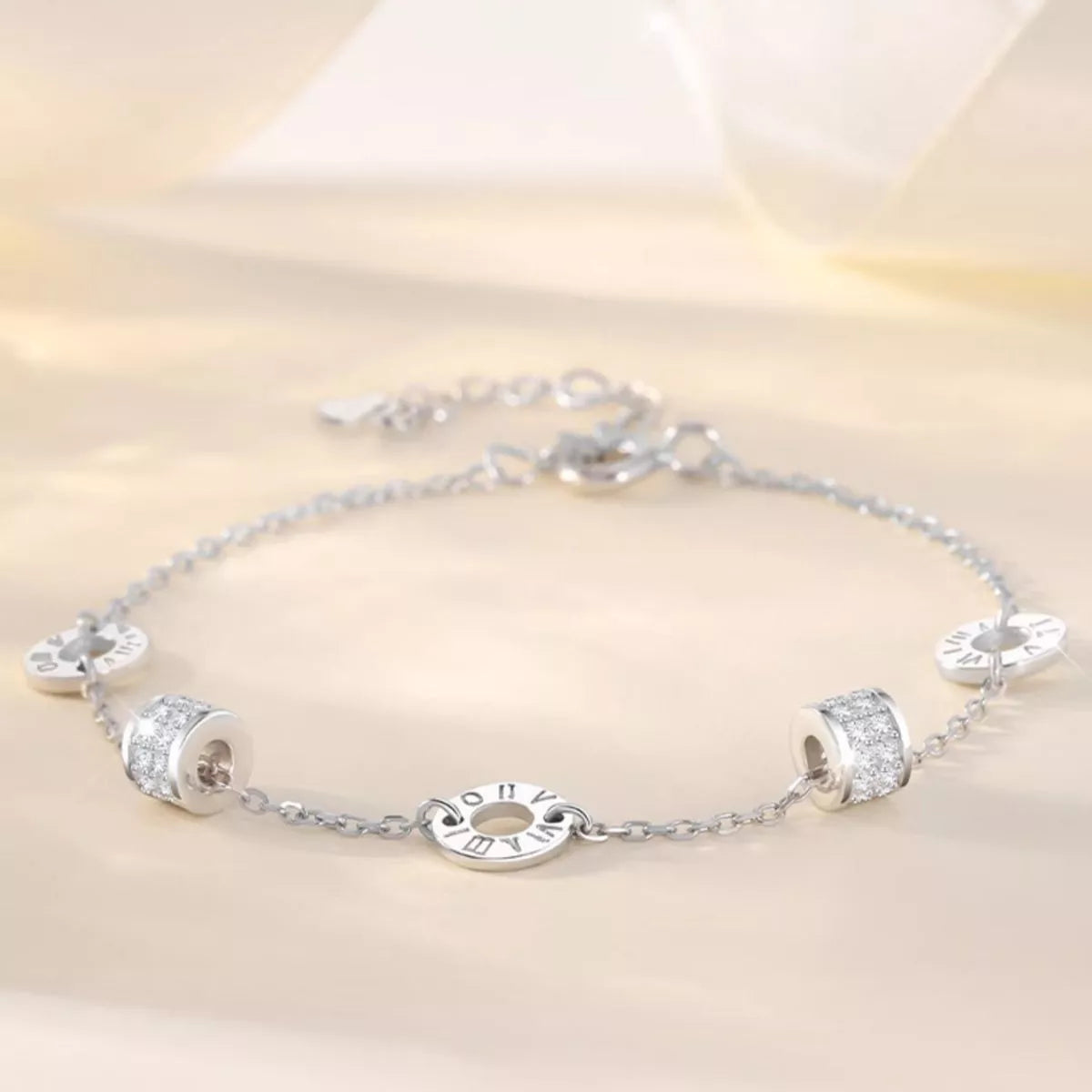 Silver bracelet with various charms on a light background