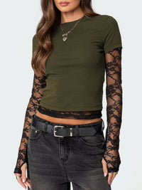 Green crop top with lace sleeves worn by a model on a white background