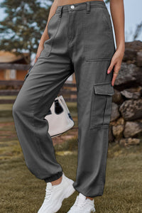 Person wearing gray cargo pants with a blurred natural background