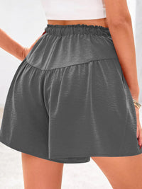 Gray shorts worn by a person on a white background