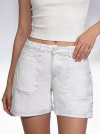 Person wearing light-colored shorts and a white top on a plain background