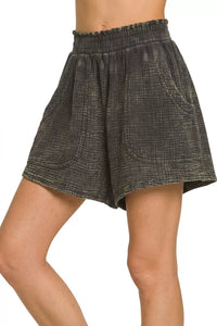 Black checkered shorts worn by a person on a white background