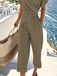 Person wearing a green jumpsuit with a scenic background of water and buildings.