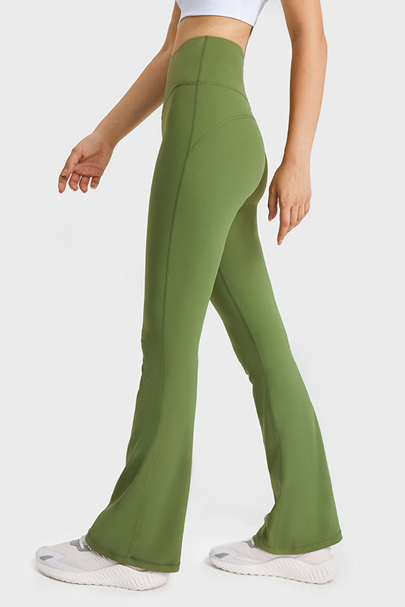 Green flared pants worn by a person on a white background