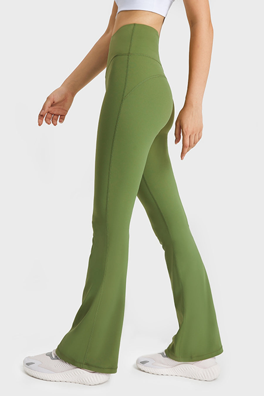 Green flared pants worn by a person on a white background