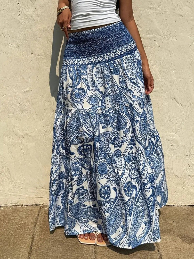 Person wearing a blue and white patterned skirt against a beige wall.