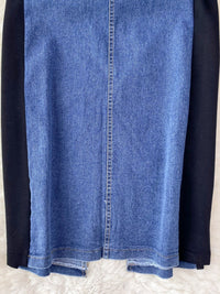 Close-up of a blue denim skirt with black sleeves on a white background
