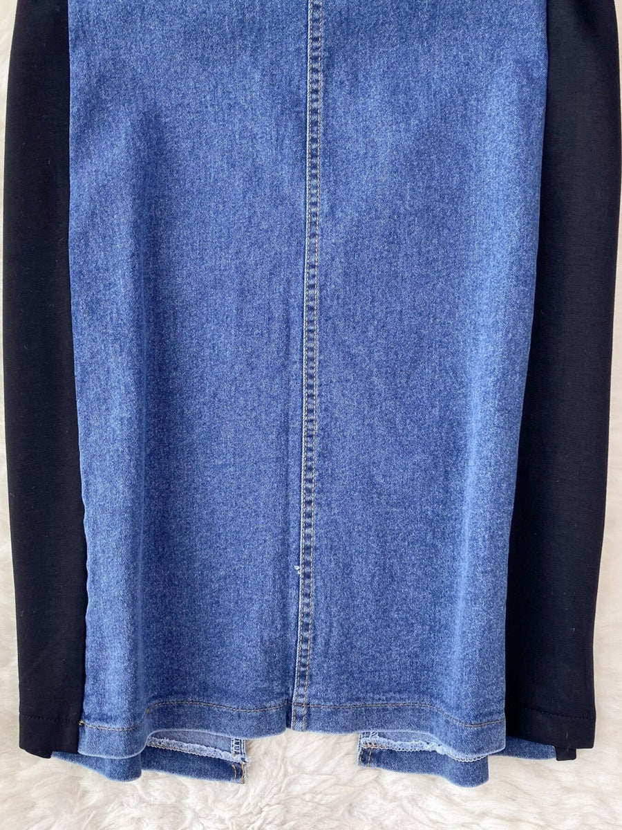 Close-up of a blue denim skirt with black sleeves on a white background