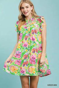 Woman wearing a colorful floral dress against a light blue background