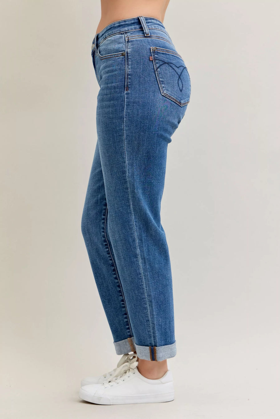 Blue jeans worn by a person on a beige background