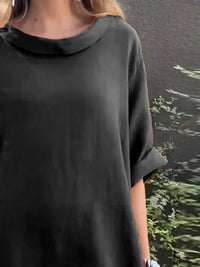 Person wearing a black oversized shirt with a blurred background
