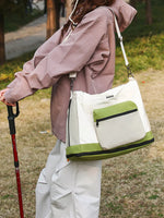 Person holding a green and white bag outdoors