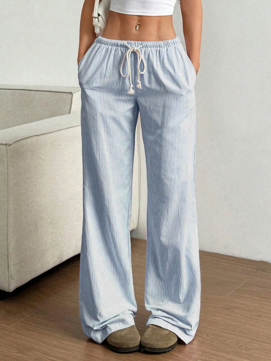 Light blue striped pants worn by a person in a minimal indoor setting