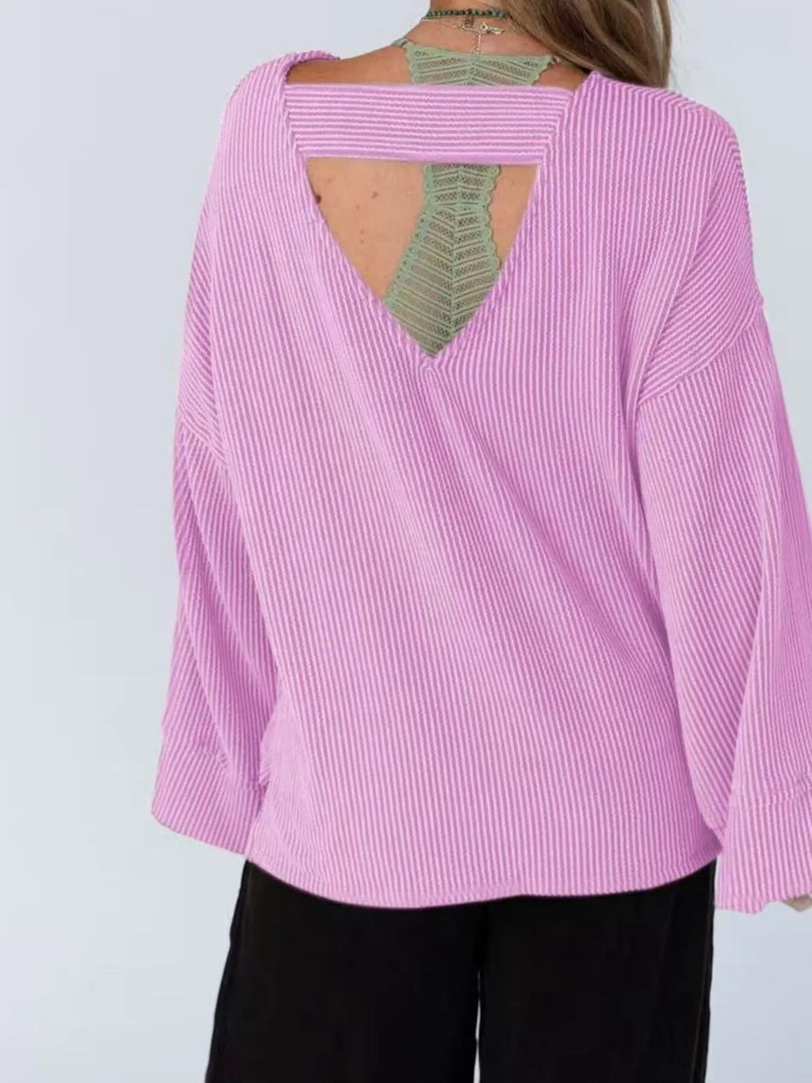 Pink blouse with open back worn by a person on a white background