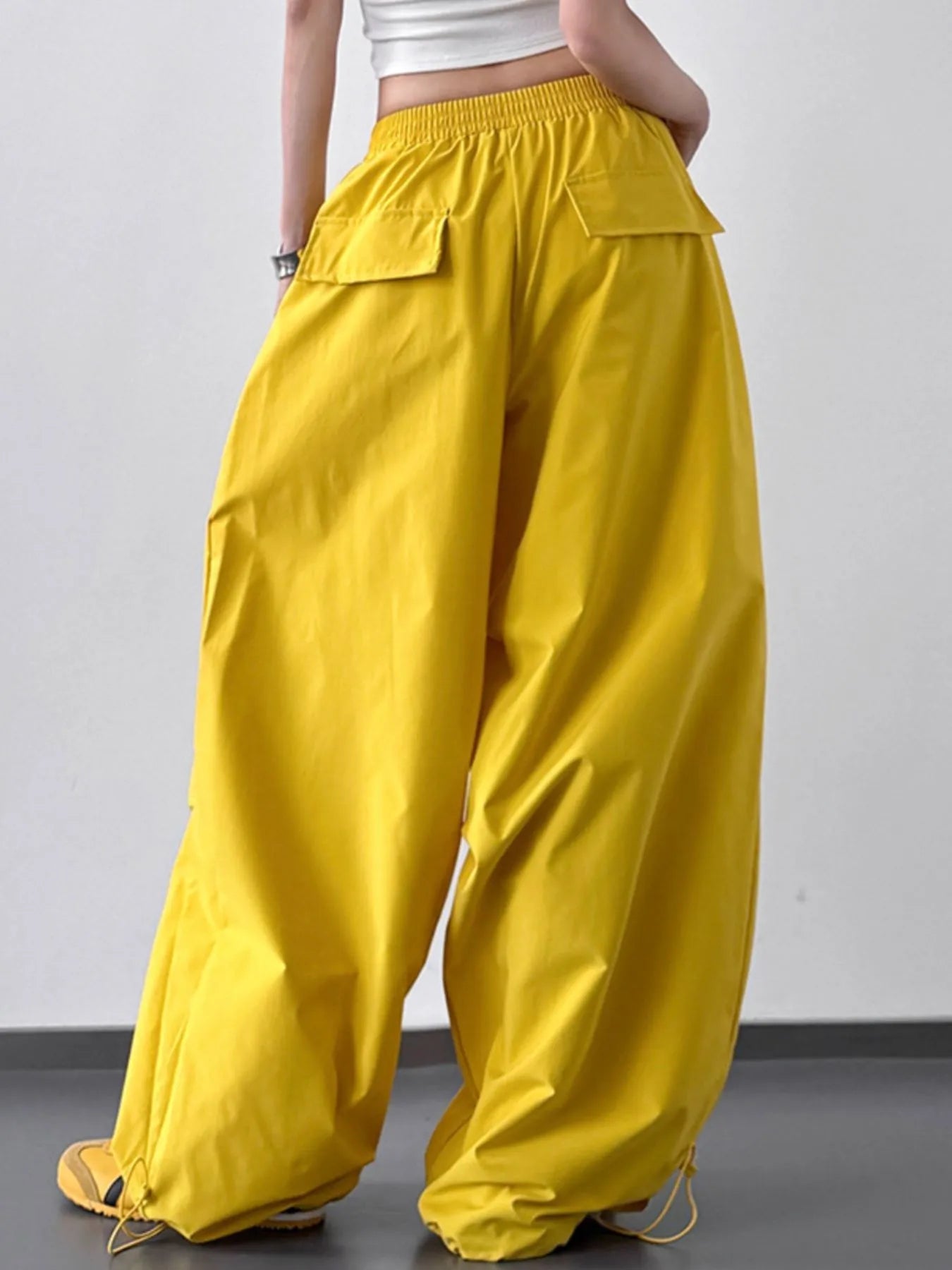 Yellow wide-leg pants worn by a person on a plain background