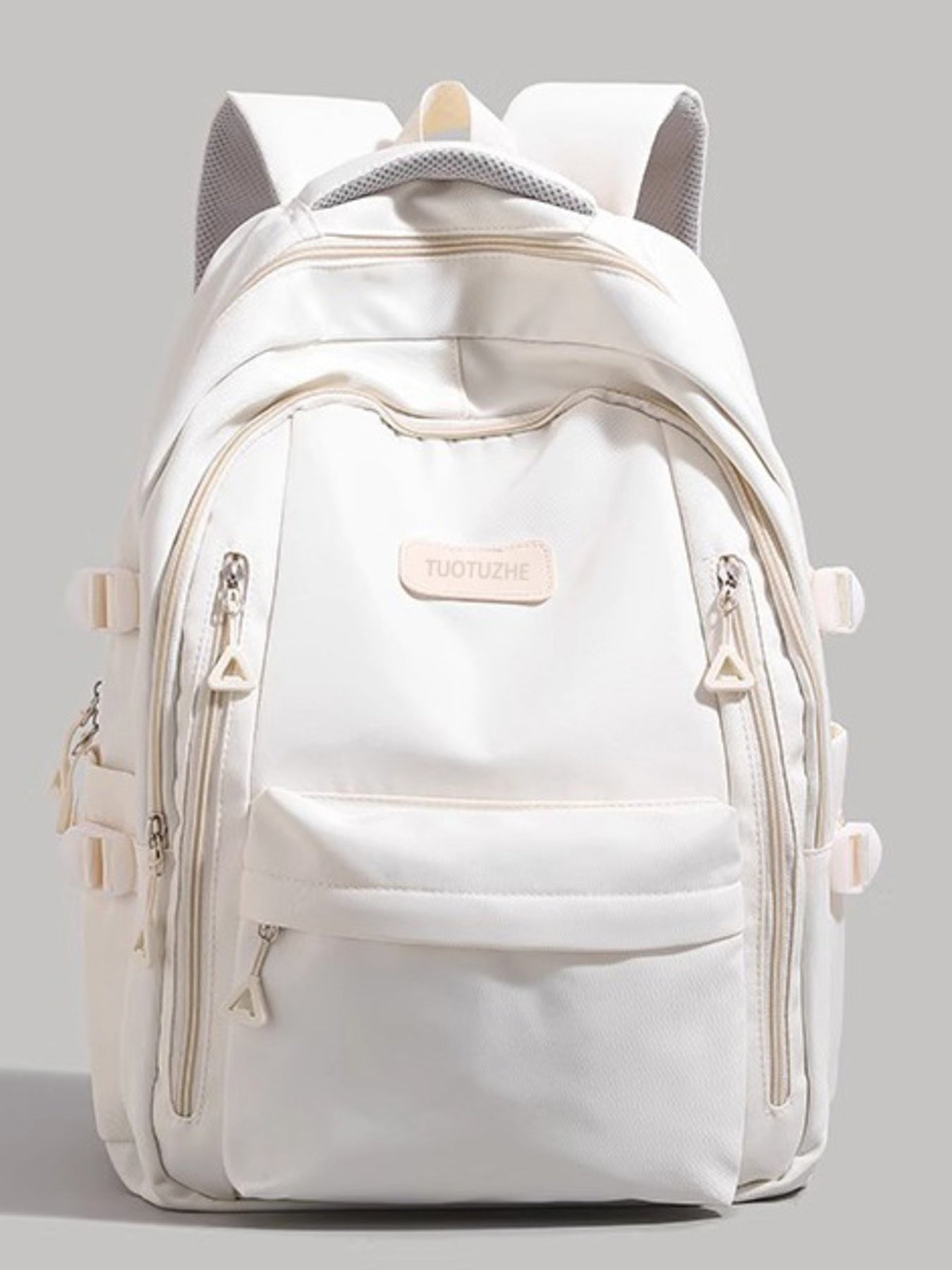 White backpack with multiple zippers on a gray background