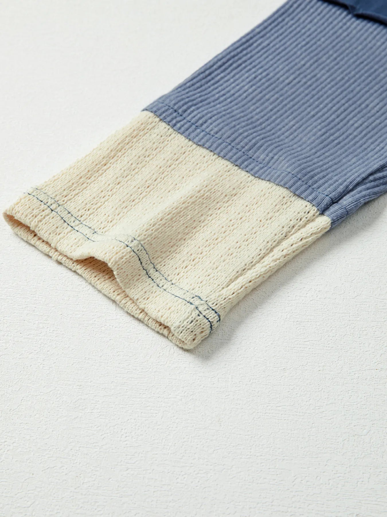 Close-up of a folded fabric with blue and beige colors on a light gray background