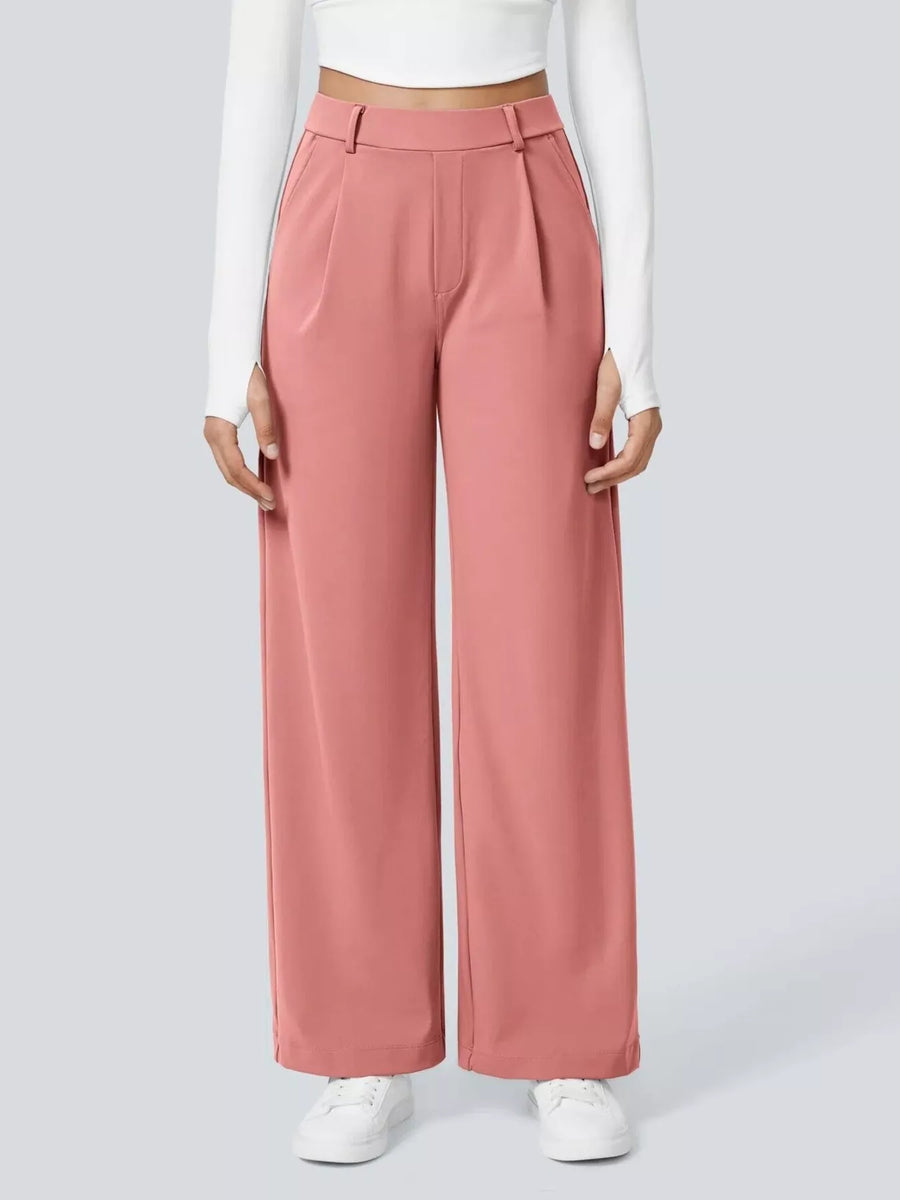 Person wearing pink wide-leg pants and white shoes on a light gray background