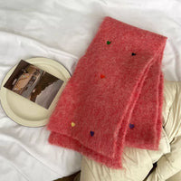 Pink scarf with colorful polka dots on a white surface