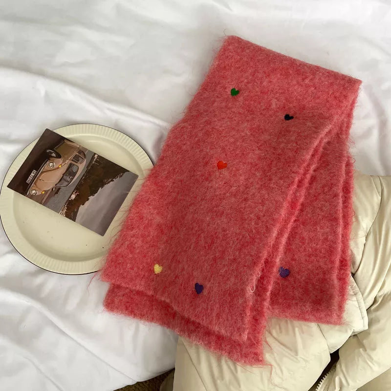 Pink scarf with colorful polka dots on a white surface