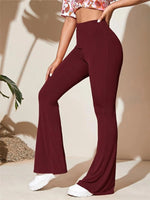 Person wearing maroon flared pants with a neutral background