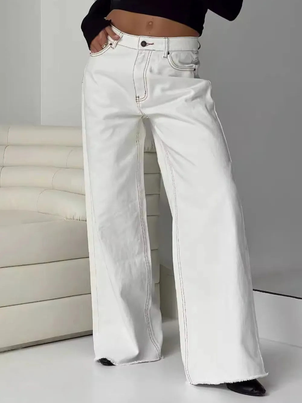 White wide-leg jeans worn by a person on a plain background