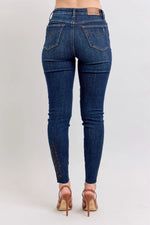Blue jeans worn by a person on a light gray background