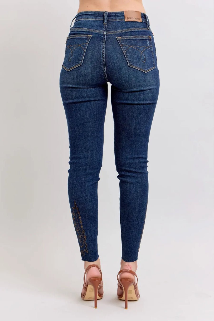 Blue jeans worn by a person on a light gray background