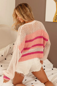 Woman wearing a pink and white striped sweater and white shorts on a polka dot blanket.