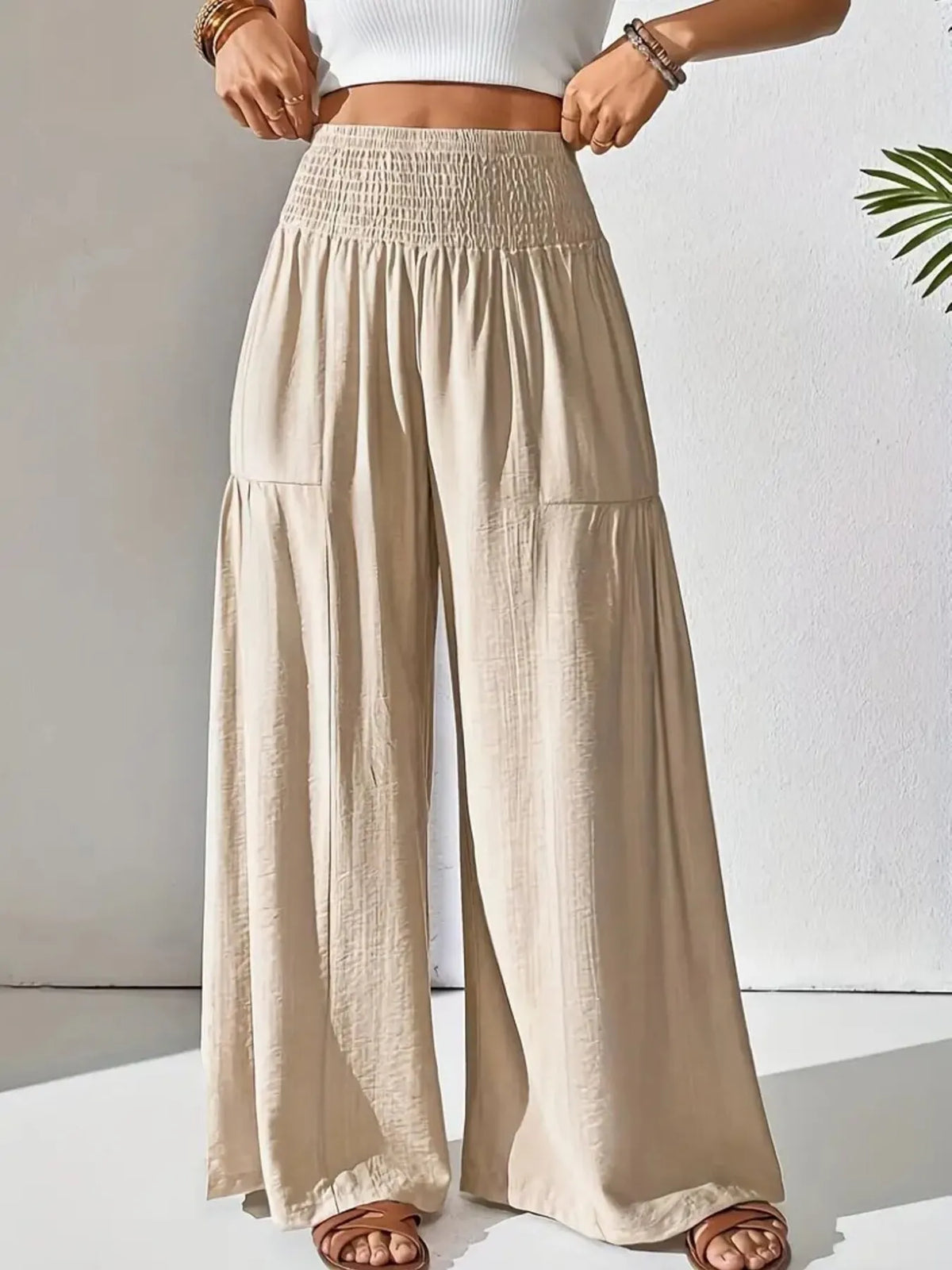 Beige wide-leg pants worn by a person on a white background
