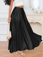 Person wearing a long black skirt with a white top in a room setting.